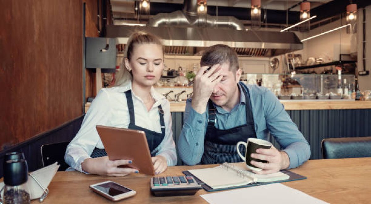 Nervous manager checking restaurant finance - Failure in small-business concept. Depressed male and female entrepreneurs overwhelmed by finance problems